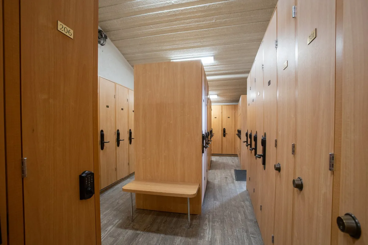 A practical ski locker room with wooden lockers, benches, and ample lighting. The layout is designed for easy gear storage and changing, providing a dedicated space for guests to stow skis, boots, and outdoor equipment after an active day.